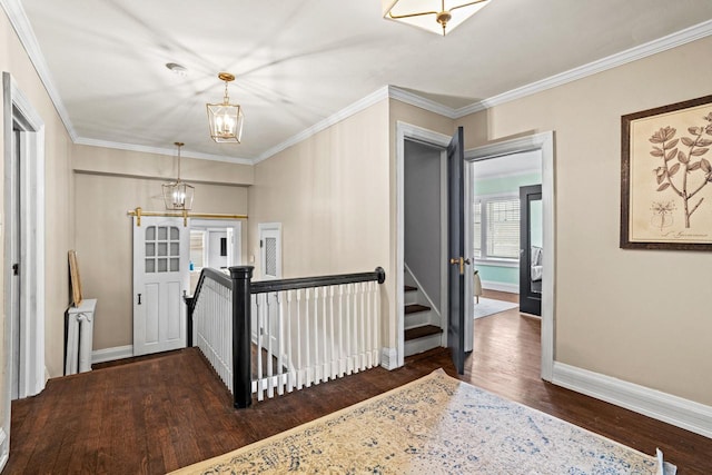 hallway featuring an inviting chandelier, ornamental molding, an upstairs landing, wood finished floors, and baseboards