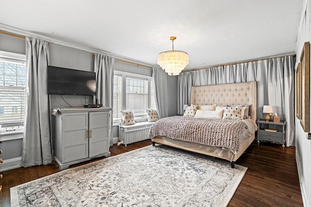 bedroom featuring an inviting chandelier, radiator heating unit, baseboards, and wood finished floors