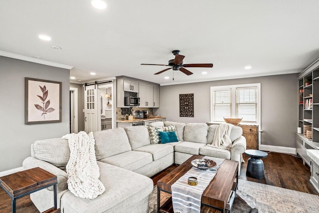 living room with a barn door, baseboards, ornamental molding, dark wood-style flooring, and recessed lighting