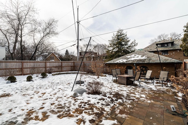 yard layered in snow with an outdoor fire pit and fence private yard