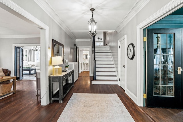 entrance foyer with stairs, ornamental molding, wood finished floors, and a chandelier