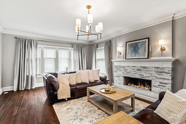 living room featuring a notable chandelier, a fireplace, ornamental molding, wood finished floors, and baseboards