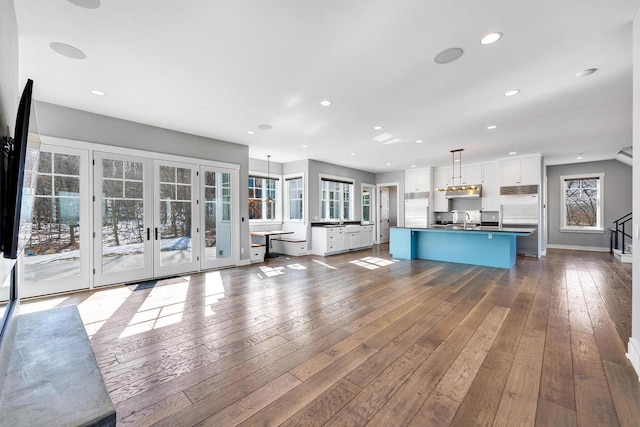 unfurnished living room featuring french doors, dark wood finished floors, recessed lighting, a sink, and baseboards