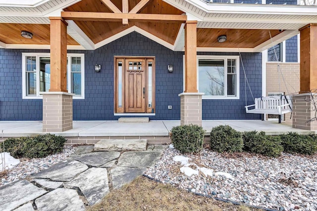 view of exterior entry featuring covered porch