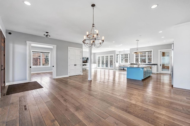 kitchen featuring open floor plan, dark wood-type flooring, a notable chandelier, a sink, and recessed lighting