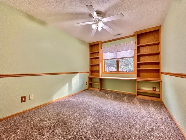 interior space with built in shelves, visible vents, a ceiling fan, a textured ceiling, and baseboards