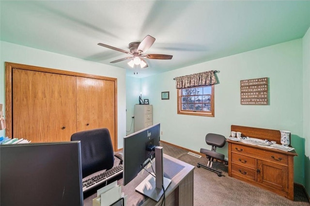 office area with carpet floors, visible vents, baseboards, and a ceiling fan