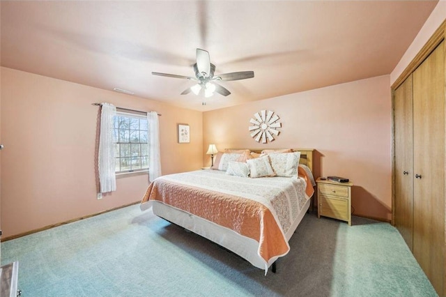 bedroom with carpet, ceiling fan, visible vents, and a closet