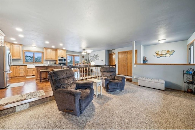 living room featuring recessed lighting, a baseboard radiator, and light wood-style floors