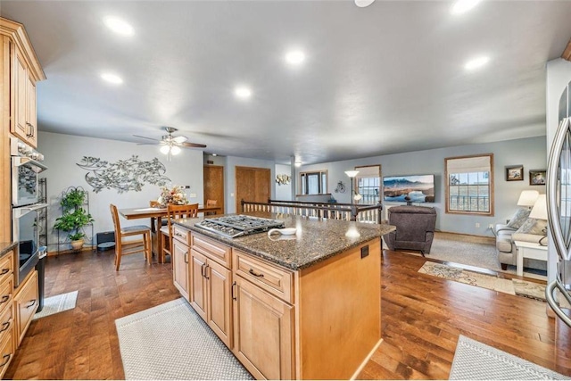 kitchen with dark wood-type flooring, open floor plan, stainless steel appliances, and a kitchen island