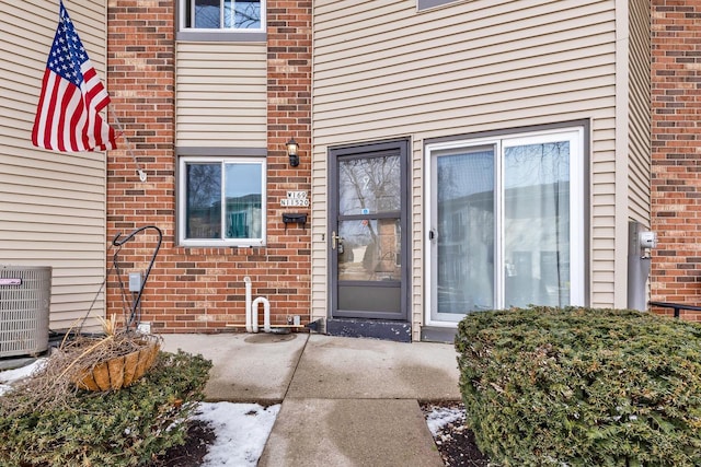 entrance to property with central AC and brick siding