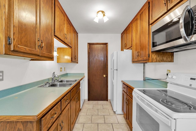 kitchen with light countertops, white appliances, brown cabinets, and a sink