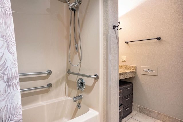 full bathroom featuring shower / bath combo, baseboards, a textured wall, tile patterned floors, and vanity