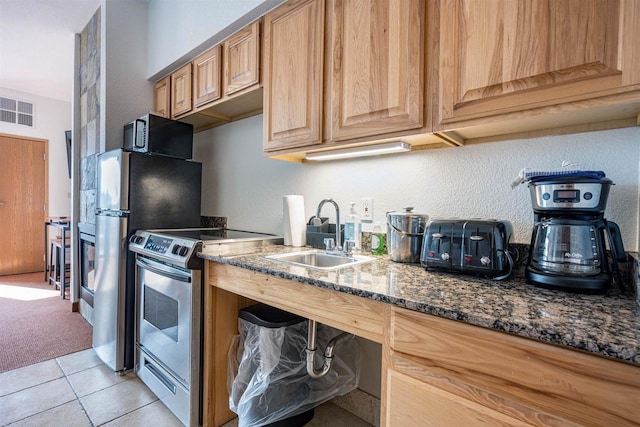 kitchen featuring black microwave, a sink, visible vents, stainless steel electric stove, and dark stone counters