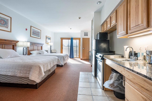 bedroom featuring light tile patterned flooring, light carpet, a sink, visible vents, and access to outside