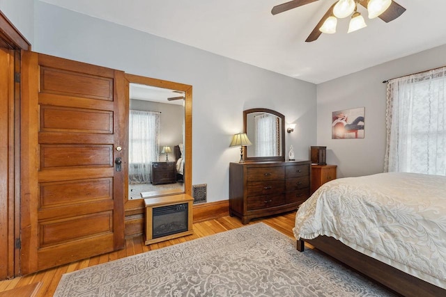 bedroom featuring a ceiling fan, baseboards, and wood finished floors