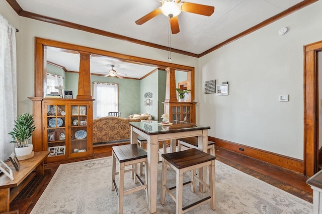 dining room with ornamental molding, hardwood / wood-style flooring, and baseboards