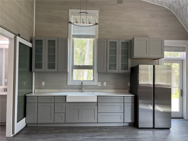 kitchen with freestanding refrigerator, gray cabinets, and a sink