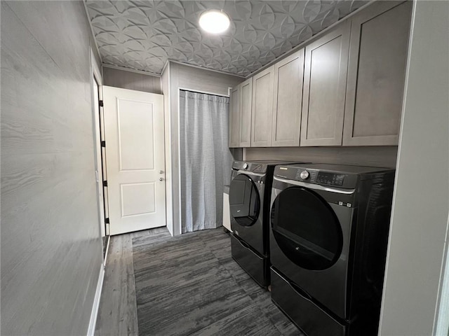 washroom with dark wood-style floors, cabinet space, and washing machine and clothes dryer