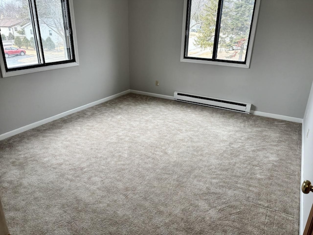 unfurnished room with carpet, baseboard heating, plenty of natural light, and baseboards