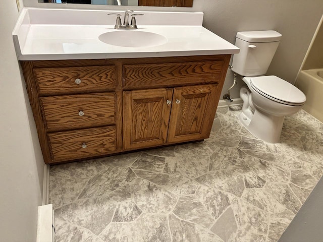 bathroom with toilet, a washtub, and vanity