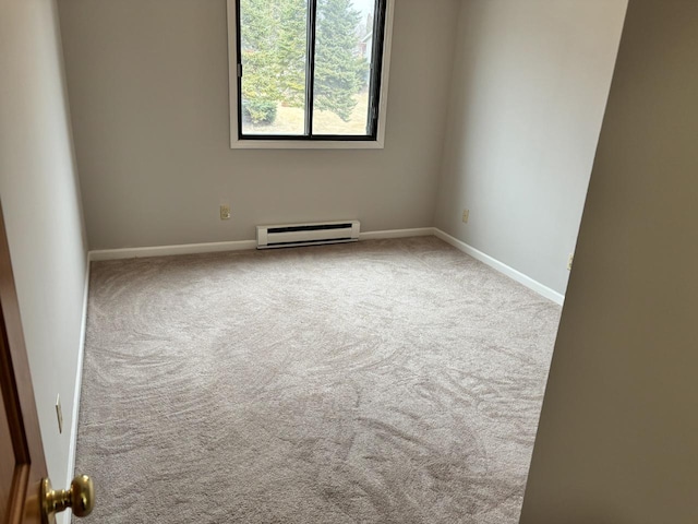 unfurnished room featuring a baseboard heating unit, carpet floors, and baseboards