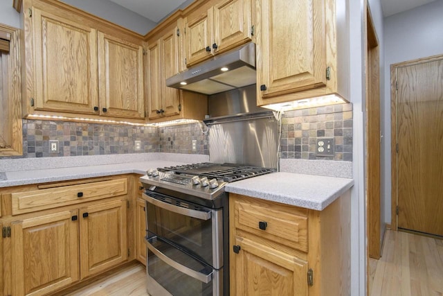 kitchen with light wood-type flooring, light countertops, double oven range, and under cabinet range hood