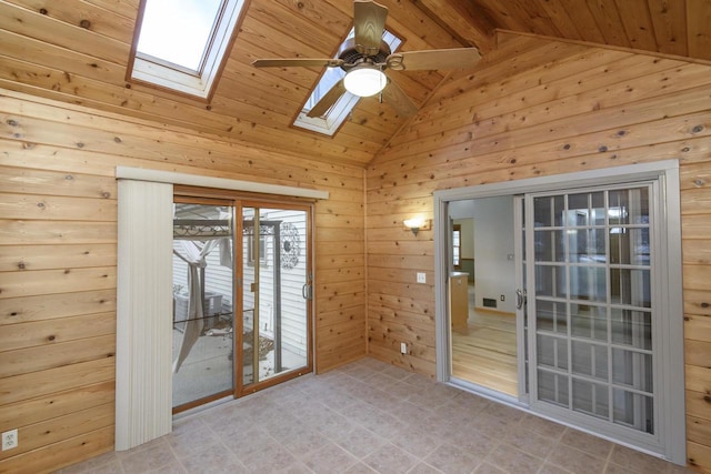 unfurnished room with vaulted ceiling with skylight, a ceiling fan, wood ceiling, and wooden walls