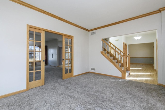 carpeted spare room with ornamental molding, french doors, stairway, and visible vents