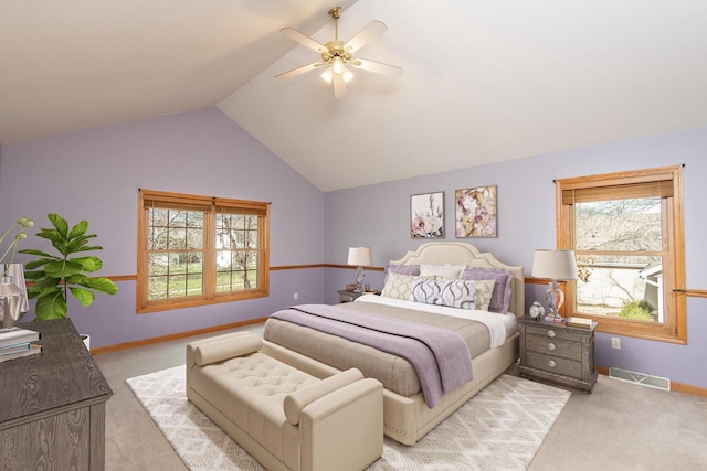 bedroom featuring a ceiling fan, visible vents, vaulted ceiling, and light carpet