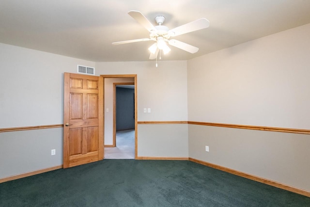 carpeted empty room with baseboards, visible vents, and a ceiling fan