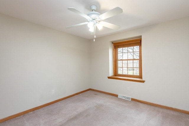 unfurnished room featuring baseboards, visible vents, ceiling fan, and light colored carpet