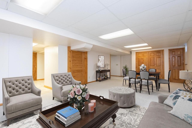 carpeted living area featuring a drop ceiling