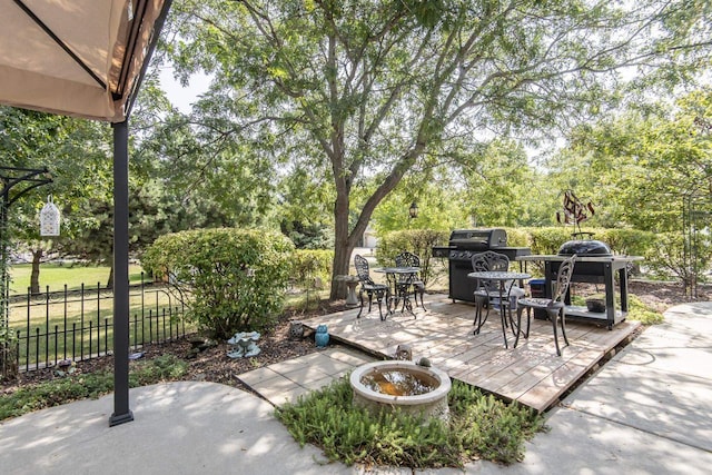 view of patio / terrace with an outdoor fire pit, fence, and a wooden deck