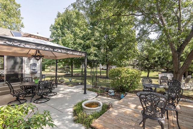 wooden terrace with a gazebo and outdoor dining space