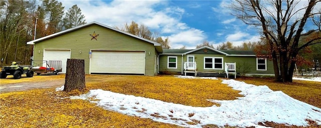 single story home featuring a garage and aphalt driveway