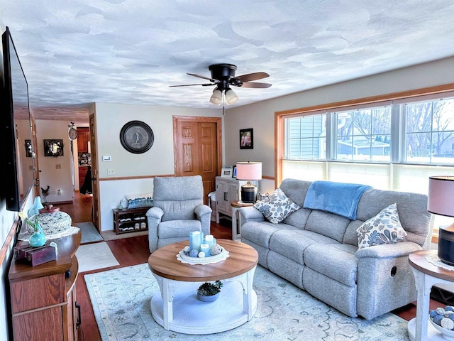 living room featuring a textured ceiling, a ceiling fan, and wood finished floors