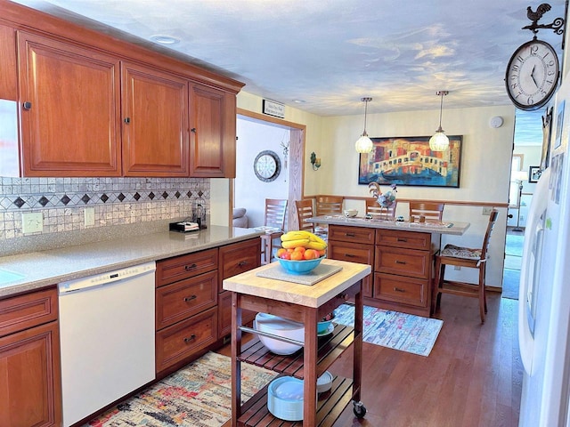 kitchen with light wood-style floors, light countertops, backsplash, brown cabinets, and dishwasher