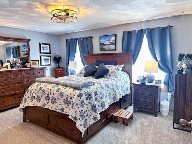 bedroom featuring light carpet and a textured ceiling