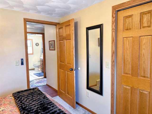 hall featuring baseboards and dark wood finished floors