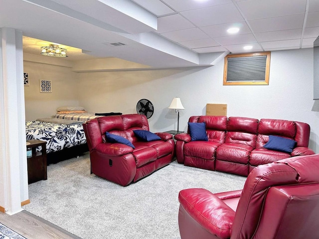 cinema room with a paneled ceiling, visible vents, carpet, and wood finished floors