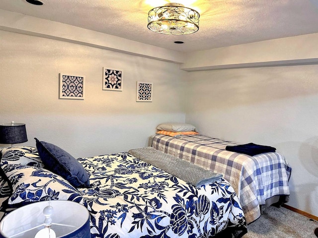 bedroom featuring a textured ceiling, carpet flooring, and baseboards