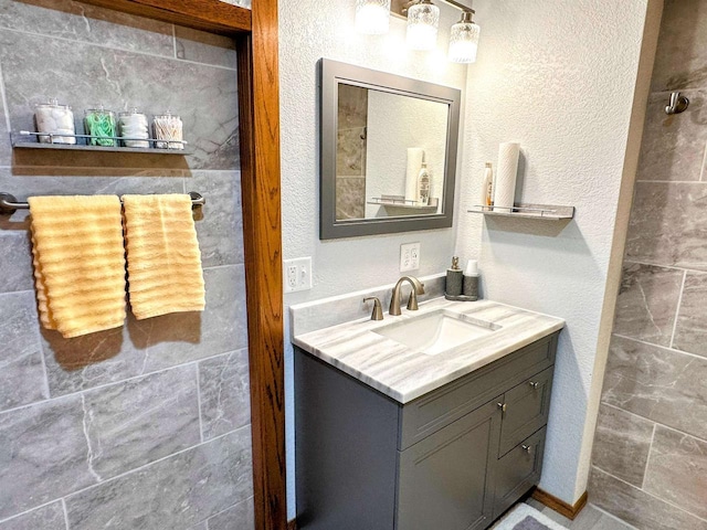 bathroom featuring a textured wall and vanity