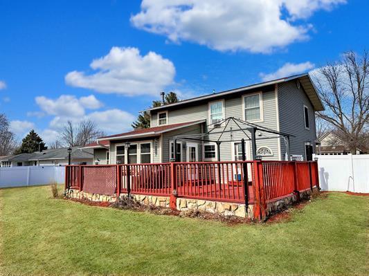 rear view of house with a yard, a fenced backyard, and a wooden deck