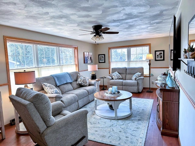 living room featuring plenty of natural light, a textured ceiling, ceiling fan, and wood finished floors