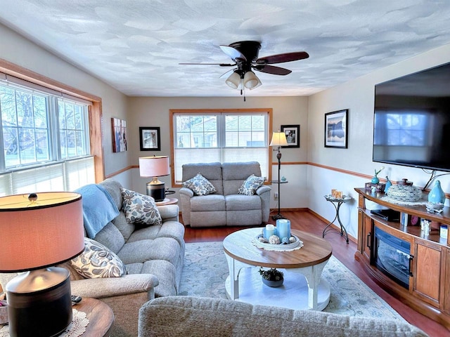 living area with plenty of natural light, a textured ceiling, a ceiling fan, and wood finished floors