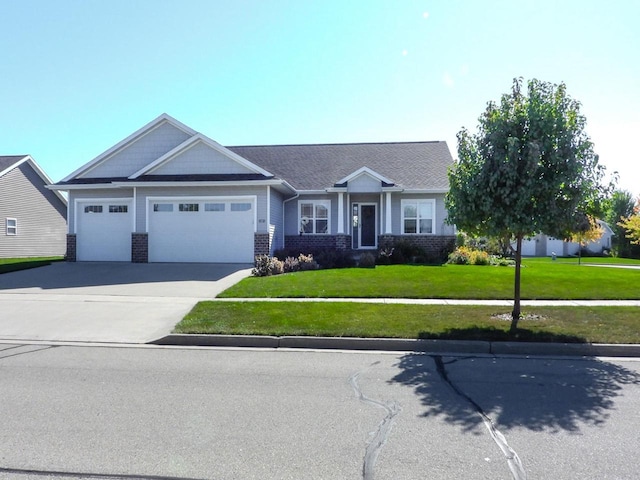 view of front of property with driveway, a front lawn, an attached garage, and brick siding