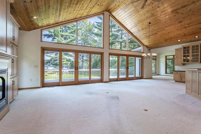 unfurnished living room with baseboards, a glass covered fireplace, light colored carpet, wood ceiling, and high vaulted ceiling