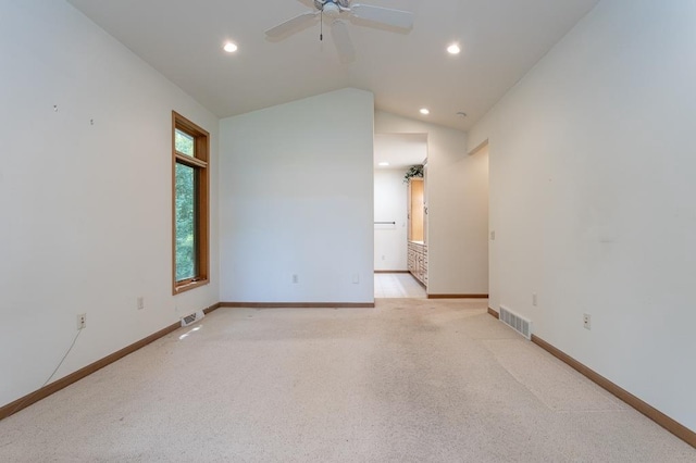 unfurnished room with lofted ceiling, baseboards, visible vents, and light colored carpet