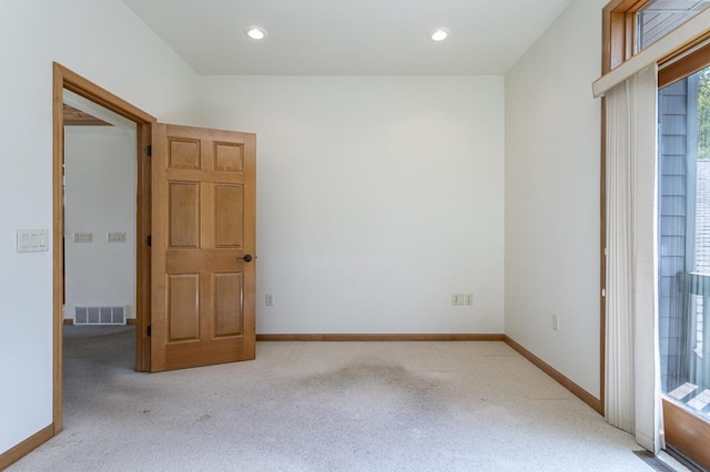 unfurnished room with light carpet, recessed lighting, visible vents, and baseboards